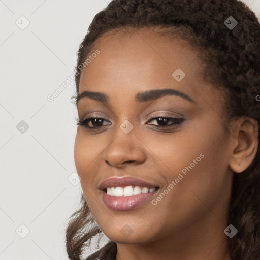 Joyful black young-adult female with long  brown hair and brown eyes