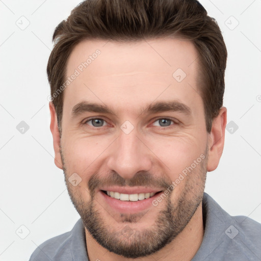 Joyful white young-adult male with short  brown hair and grey eyes