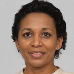 Joyful black adult female with short  brown hair and brown eyes