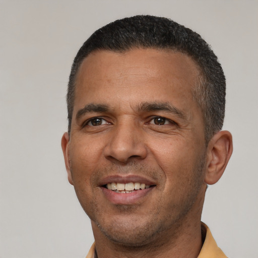 Joyful latino adult male with short  brown hair and brown eyes