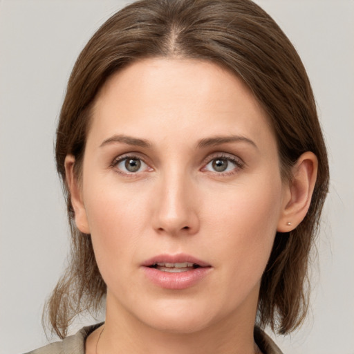 Joyful white young-adult female with medium  brown hair and grey eyes