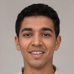 Joyful latino young-adult male with short  black hair and brown eyes