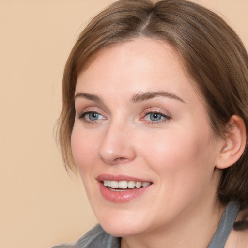 Joyful white young-adult female with medium  brown hair and grey eyes