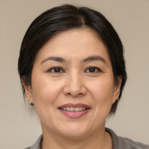 Joyful asian adult female with medium  brown hair and brown eyes