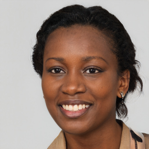 Joyful black young-adult female with short  black hair and brown eyes