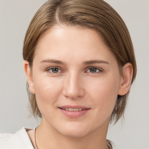 Joyful white young-adult female with medium  brown hair and grey eyes