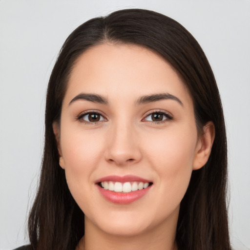 Joyful white young-adult female with long  brown hair and brown eyes