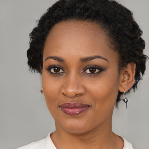 Joyful black young-adult female with short  black hair and brown eyes