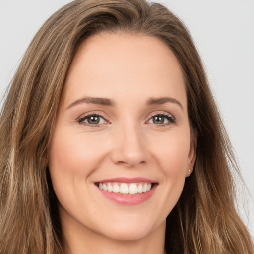 Joyful white young-adult female with long  brown hair and brown eyes