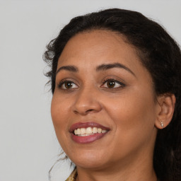 Joyful black adult female with long  brown hair and brown eyes