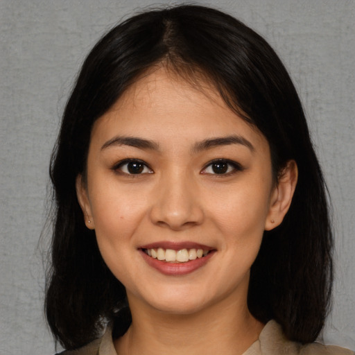 Joyful asian young-adult female with long  brown hair and brown eyes
