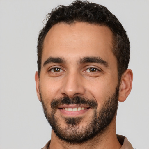 Joyful white young-adult male with short  black hair and brown eyes