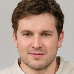 Joyful white young-adult male with short  brown hair and grey eyes