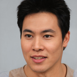 Joyful asian young-adult male with short  brown hair and brown eyes