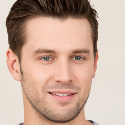 Joyful white young-adult male with short  brown hair and grey eyes