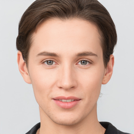 Joyful white young-adult male with short  brown hair and grey eyes