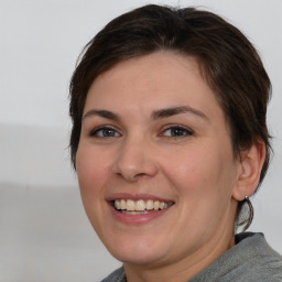 Joyful white young-adult female with medium  brown hair and brown eyes