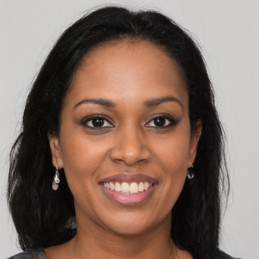 Joyful black young-adult female with long  brown hair and brown eyes