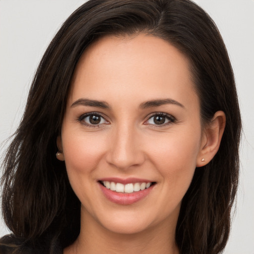 Joyful white young-adult female with long  brown hair and brown eyes