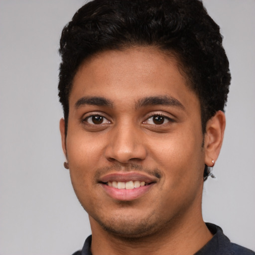 Joyful latino young-adult male with short  black hair and brown eyes