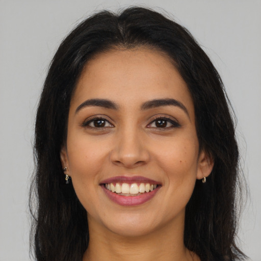 Joyful latino young-adult female with long  brown hair and brown eyes