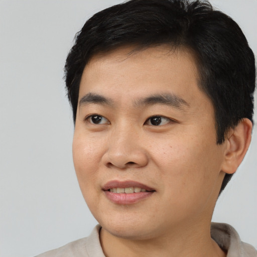 Joyful asian young-adult male with short  black hair and brown eyes