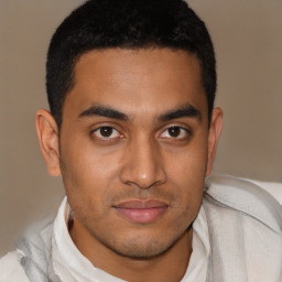 Joyful latino young-adult male with short  brown hair and brown eyes