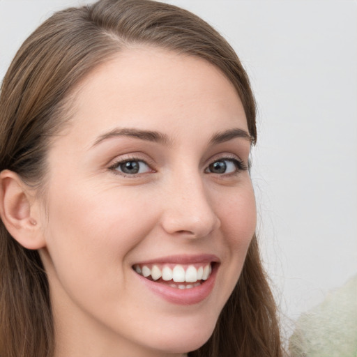 Joyful white young-adult female with long  brown hair and blue eyes