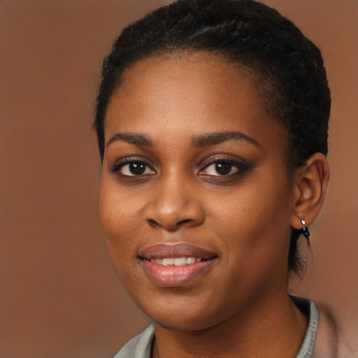 Joyful black young-adult female with long  brown hair and brown eyes