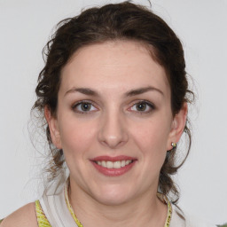 Joyful white young-adult female with medium  brown hair and green eyes