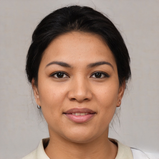 Joyful latino young-adult female with medium  brown hair and brown eyes
