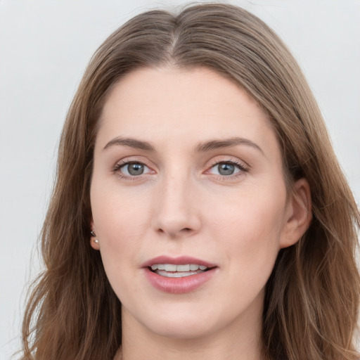 Joyful white young-adult female with long  brown hair and grey eyes