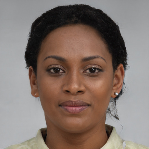 Joyful black young-adult female with short  black hair and brown eyes