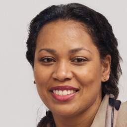 Joyful black adult female with long  brown hair and brown eyes