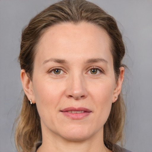 Joyful white adult female with medium  brown hair and grey eyes