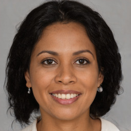 Joyful latino adult female with medium  brown hair and brown eyes