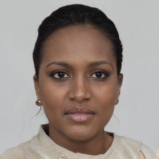 Joyful black young-adult female with short  black hair and brown eyes
