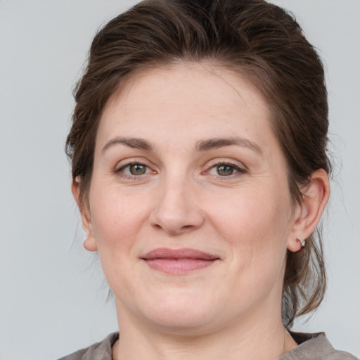 Joyful white adult female with medium  brown hair and grey eyes