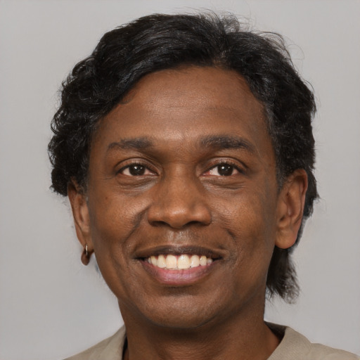 Joyful black adult male with medium  brown hair and brown eyes