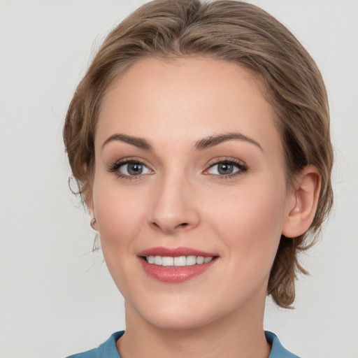 Joyful white young-adult female with medium  brown hair and grey eyes