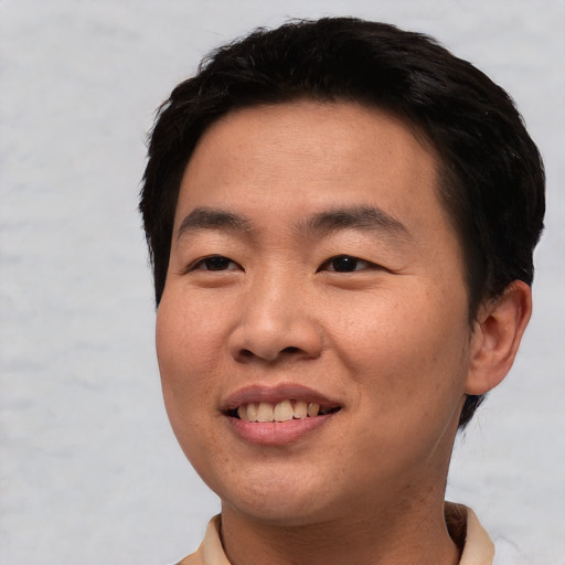Joyful asian young-adult male with short  black hair and brown eyes