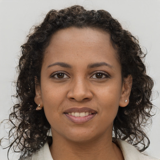 Joyful black young-adult female with long  brown hair and brown eyes