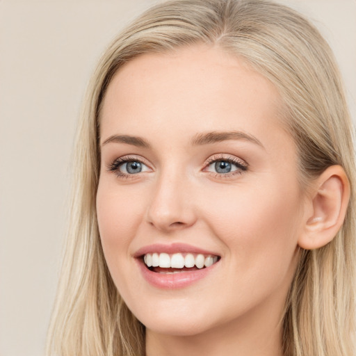 Joyful white young-adult female with long  brown hair and blue eyes