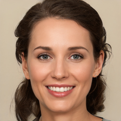 Joyful white young-adult female with medium  brown hair and green eyes