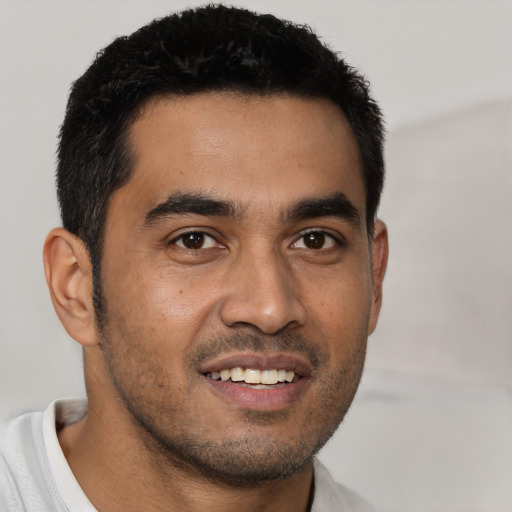 Joyful latino young-adult male with short  black hair and brown eyes