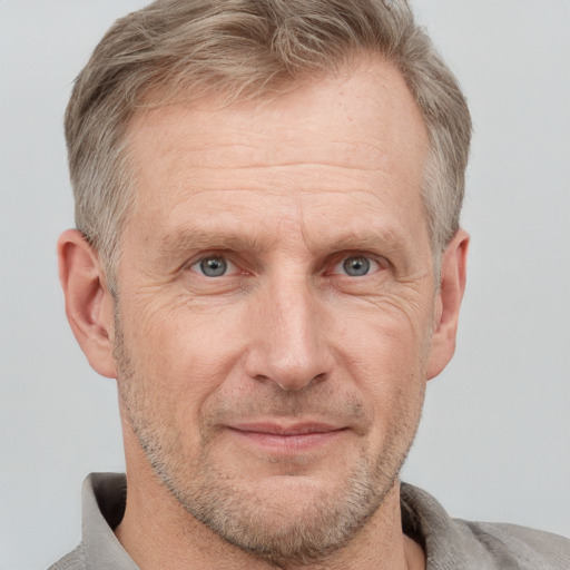 Joyful white middle-aged male with short  brown hair and grey eyes