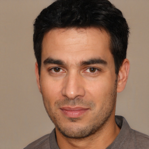 Joyful white young-adult male with short  black hair and brown eyes