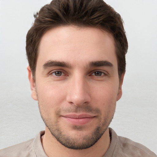 Joyful white young-adult male with short  brown hair and grey eyes