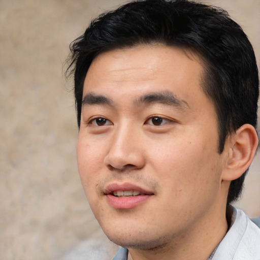 Joyful asian young-adult male with short  black hair and brown eyes