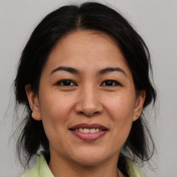 Joyful asian adult female with medium  brown hair and brown eyes